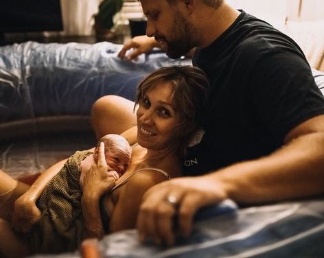 Physical Therapy A pregnant woman leans on an exercise ball while a physical therapist demonstrates a pelvic floor exercise.